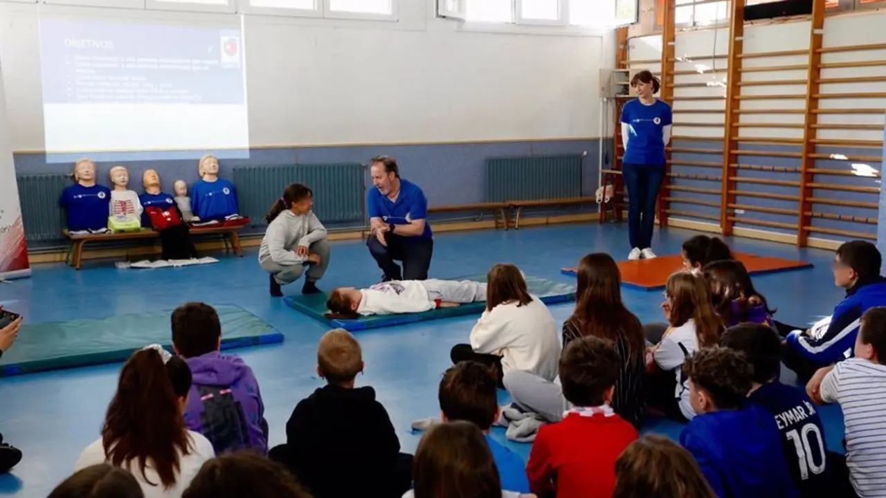 Ni&ntilde;o y profesional con una maqueta de un cuerpo practicando la RCP