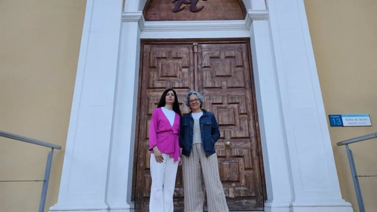 Dos mujeres frente a una puerta de entrada grande