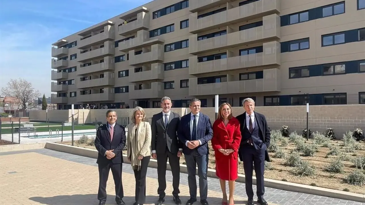 Personas trajeadas frente a edificios de vivienda