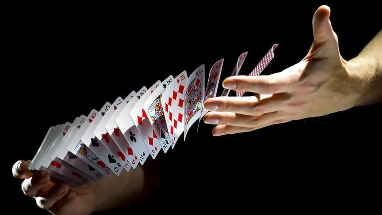 Dos manos barajando cartas al vuelo