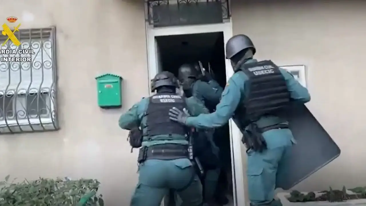 Agentes de la Guardia Civil accediendo a una vivienda por orden de registro