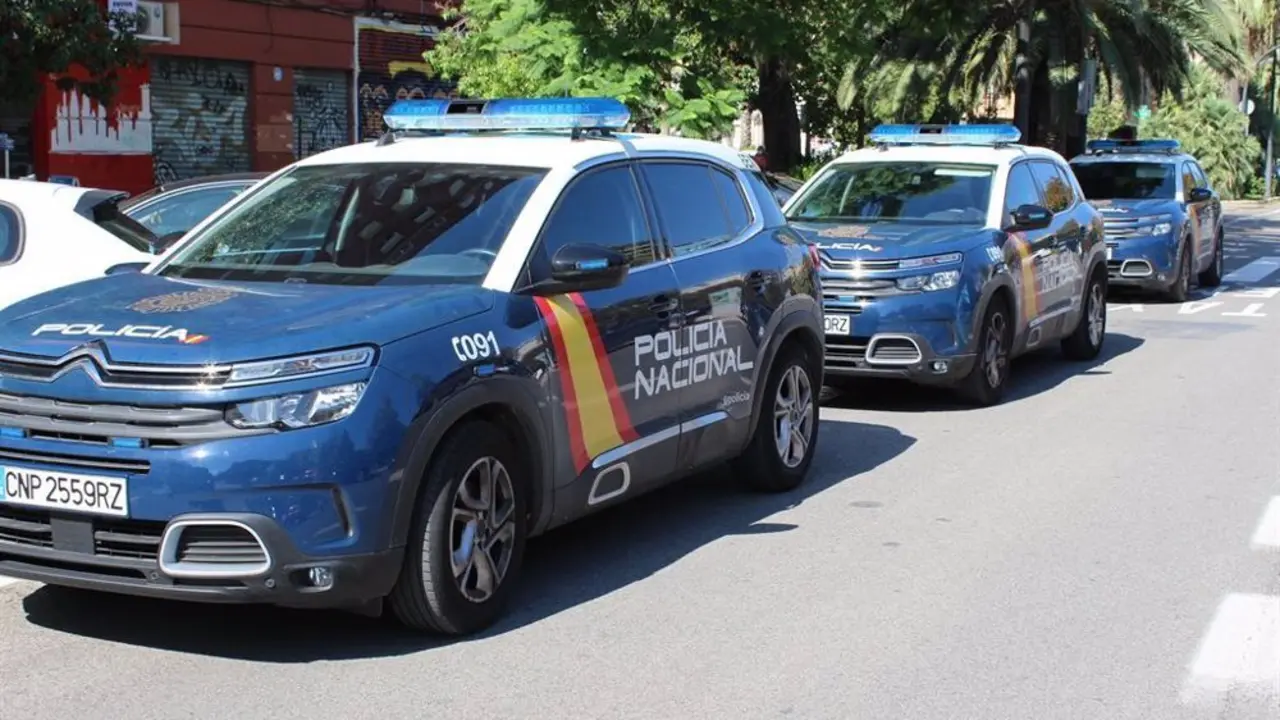 Tres coches consecutivos de la Polic&iacute;a Nacional sobre una carretera de ciudad