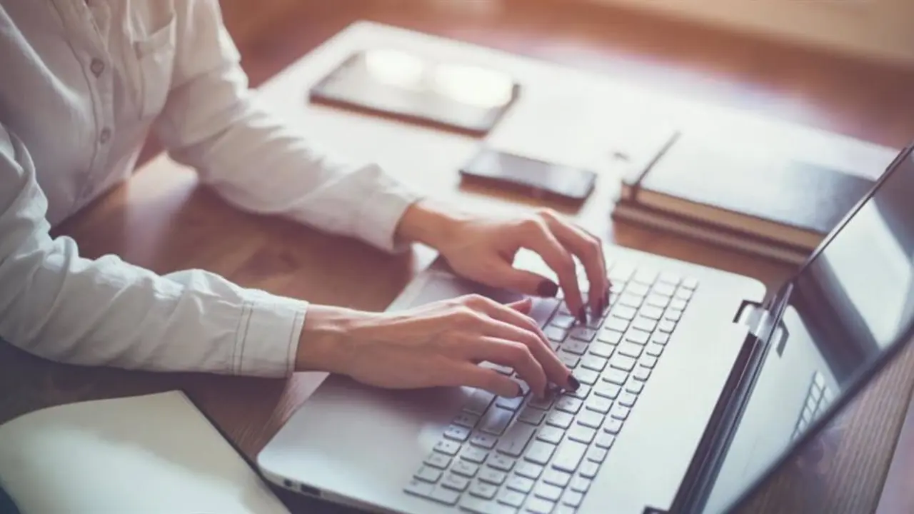 Persona con sus manos sobre el teclado de un ordenador
