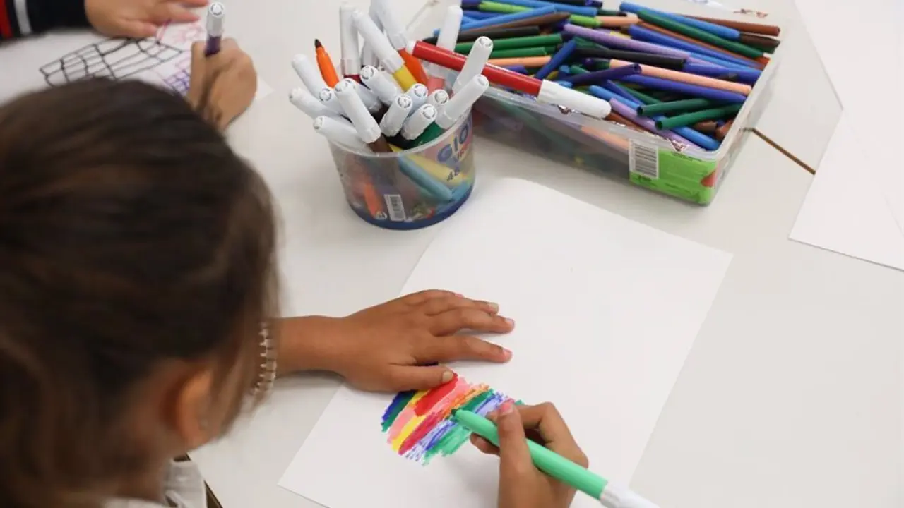 Ni&ntilde;a pintando un folio con rotuladores