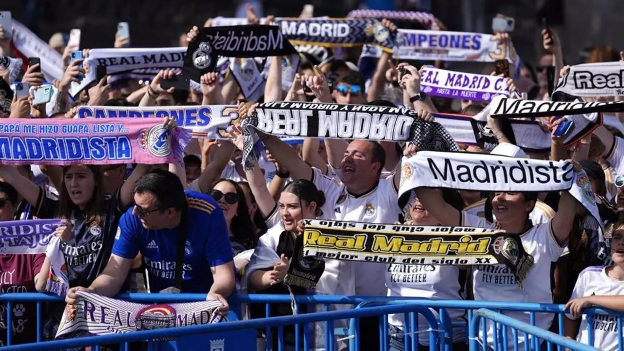 Fan&aacute;ticos del Real Madrid levantando sus bufandas del equipo