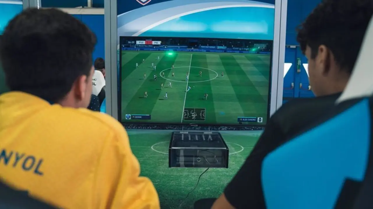 Dos chicos jugando a un videojuego de f&uacute;tbol