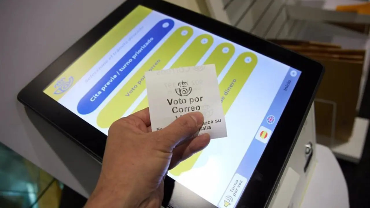 Mano sosteniendo un papel que indica "voto por correo"
