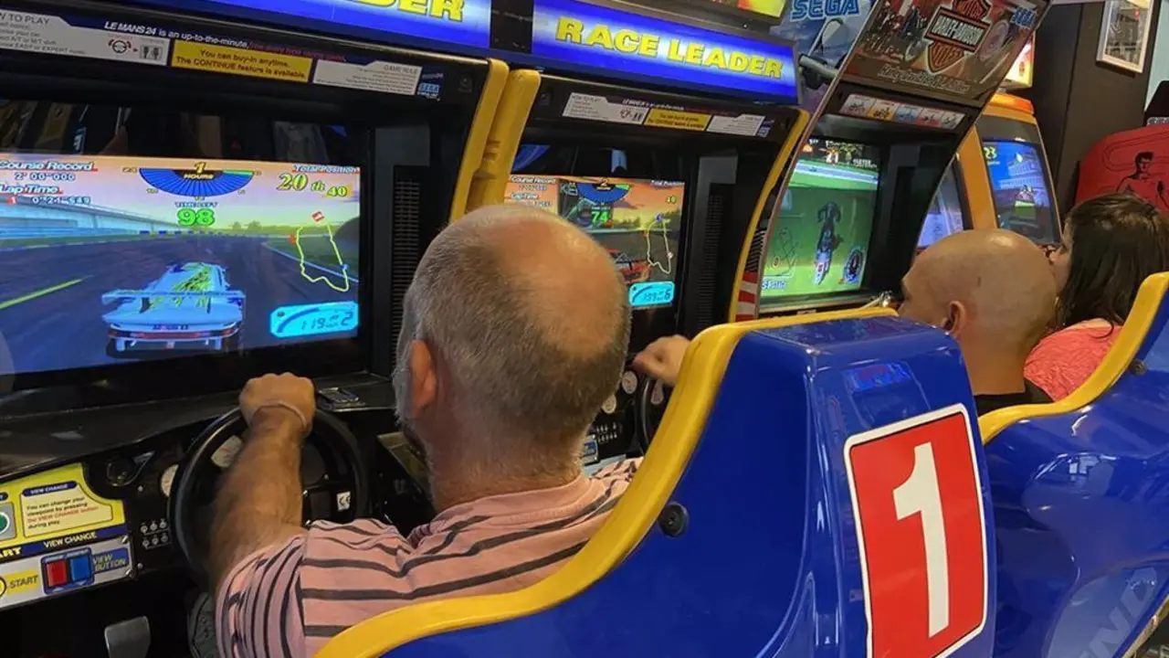 Dos homrbes jugando en m&aacute;quinas recreativas