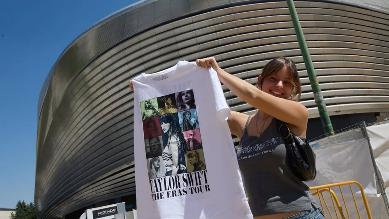 Chica sosteniendo una camiseta del merchandising de Taylor Swift