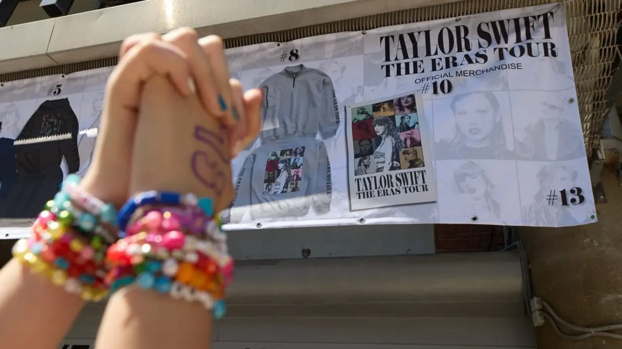 Dos manos entrelazadas frente al puesto de merchandising del concierto de Taylor Swift en Madrid