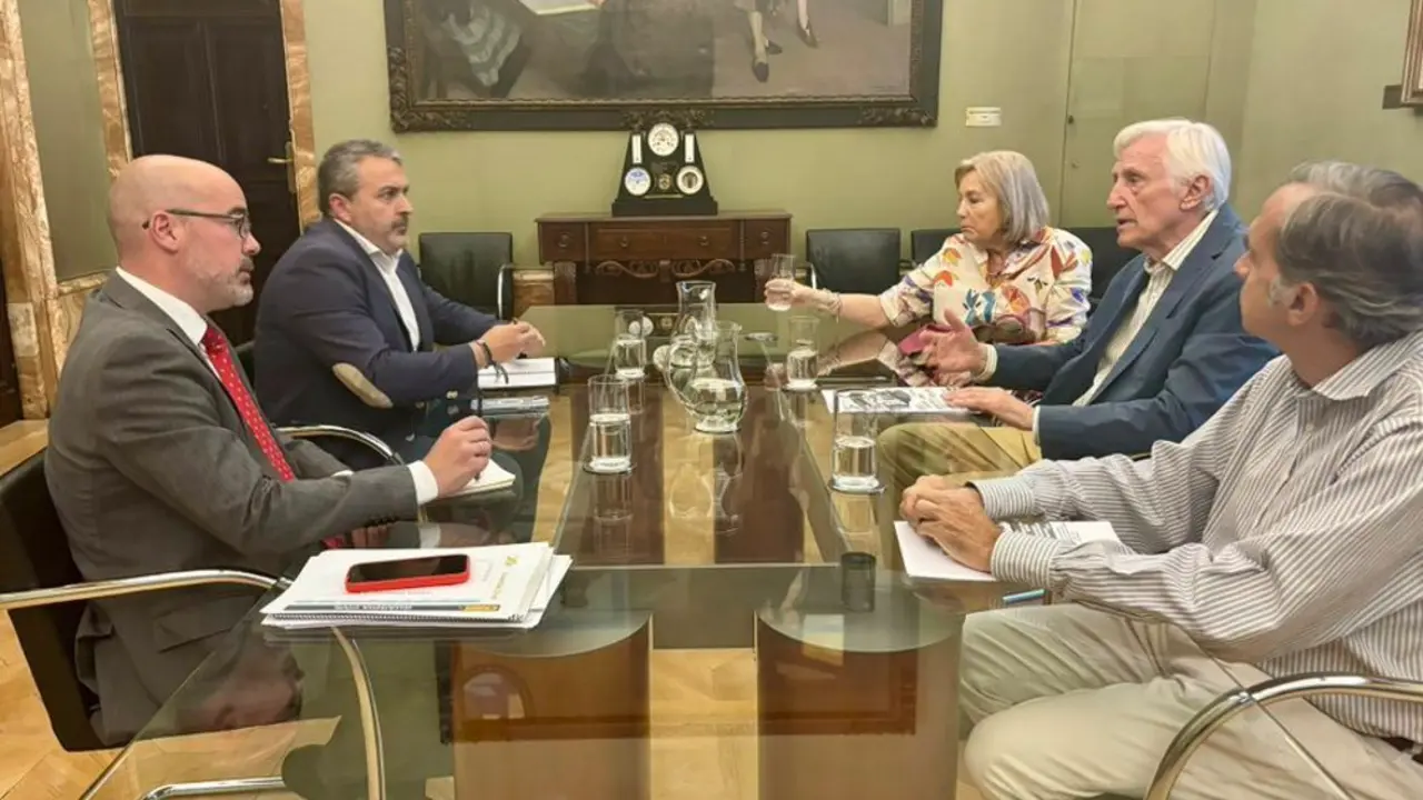 Personas reunidas alrededor de una mesa cuadrada