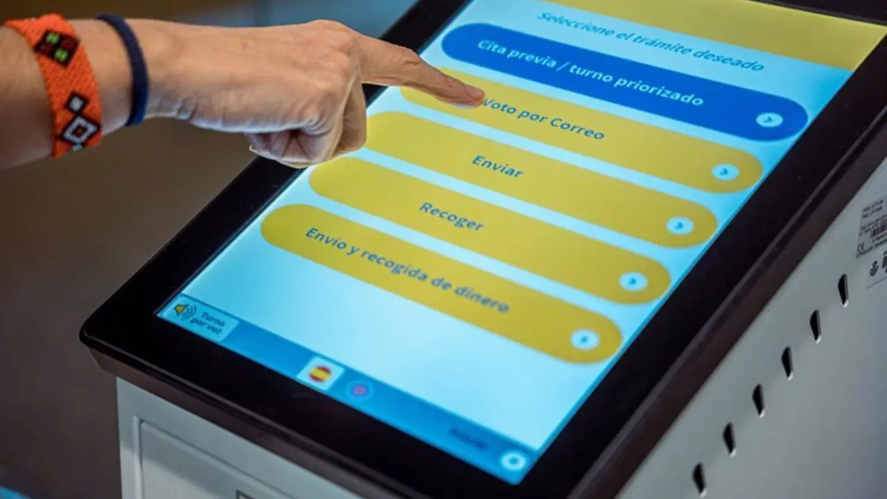 Dedo sobre una tablet indicando un bot&oacute;n en el que aparece escrito "Voto por correo"