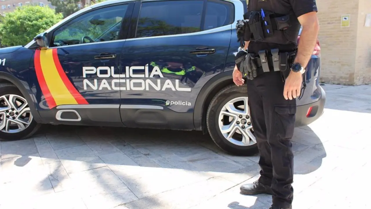 Imagen de archivo de un coche de la Polic&iacute;a Nacional junto con un agente.
