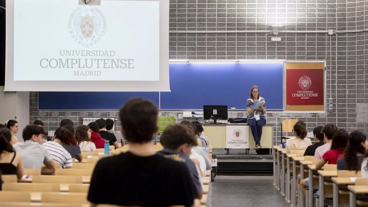Varios estudiantes de la universidad complutense sentados atendiendo a la profesora