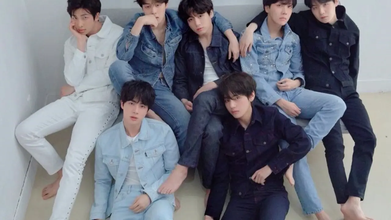 Una de las bandas de K-Pop del Festival conformada por siete integrantes posando sentados vestido de Denim