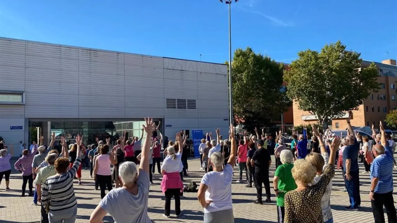 Un grupo de personas mayores bailando en una masterclass de zumba al aire libre 