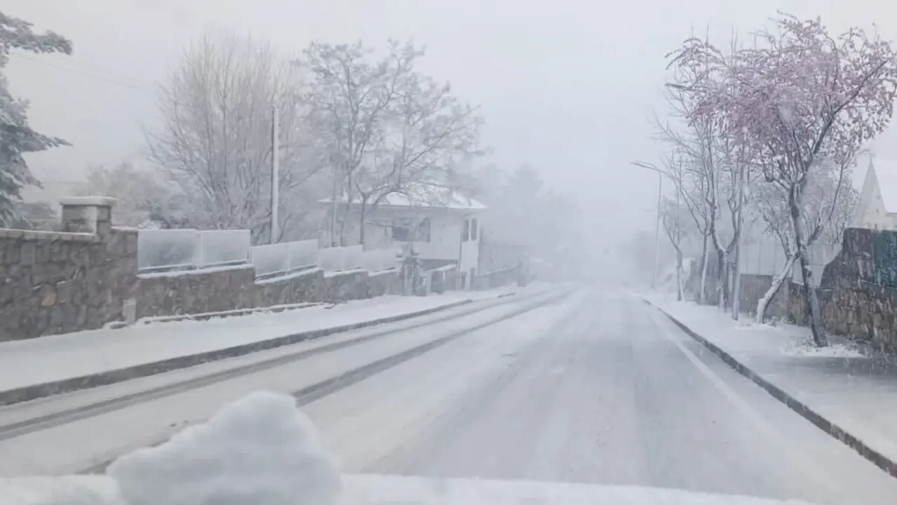 Fotograf&iacute;a tomada desde un coche de una carretera nevada en un d&iacute;a nublado donde no se ve el cielo