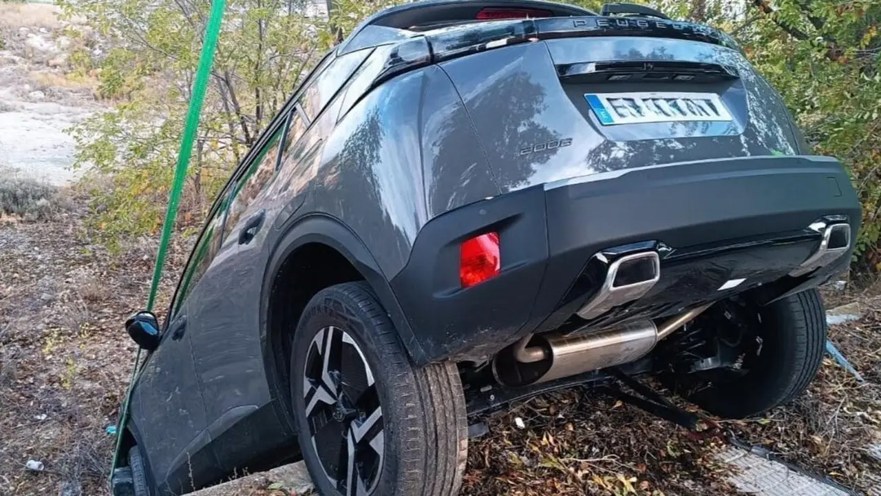 Un coche ca&iacute;do por un terrapl&eacute;n con las dos ruedas traseras a&uacute;n en la acera