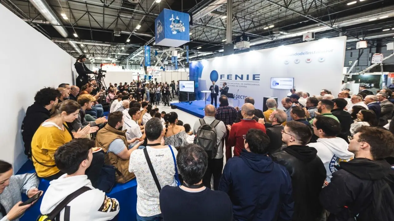 Imagen de la feria en a&ntilde;os anteriores donde se ve a un grupo de personas y medios atendiendo a la charla de unos de los expertos de la Feria