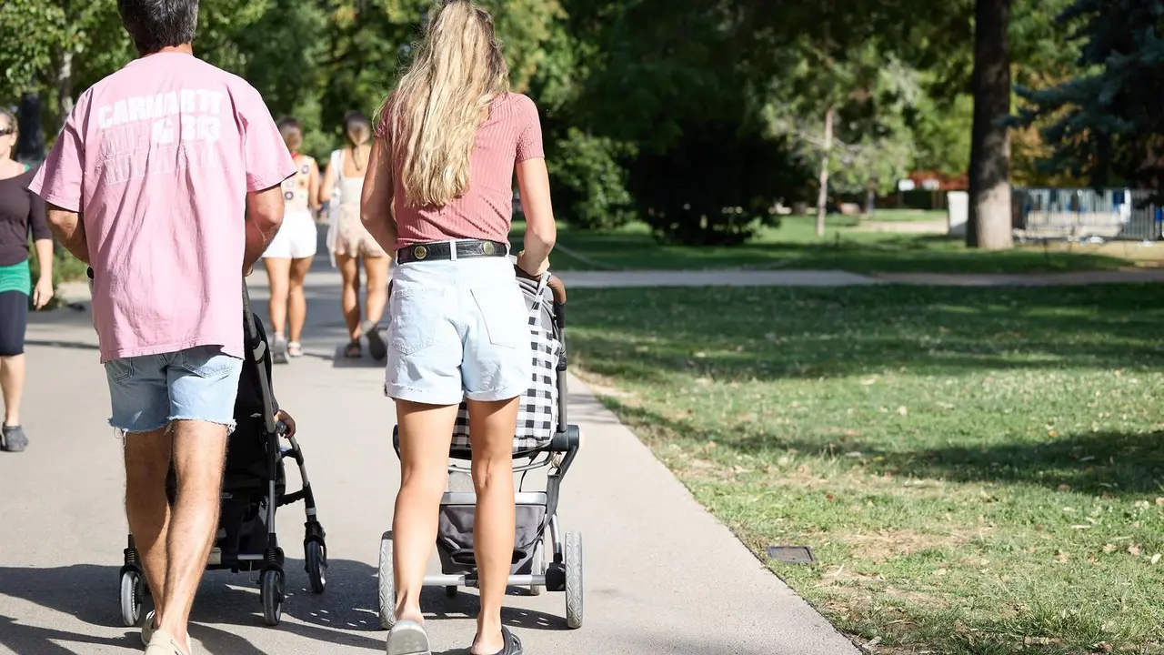 Una pareja con dos carritos de beb&eacute;s en el Parque de El Retiro paseando&nbsp;