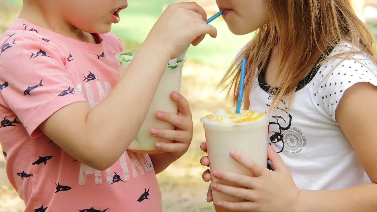 Dos ni&ntilde;os compartiendo un batido