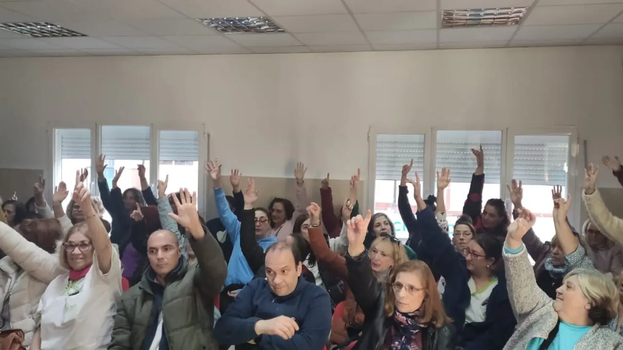Imagen de trabajadores y trabajadoras alzando las manos en una concentraci&oacute;n.