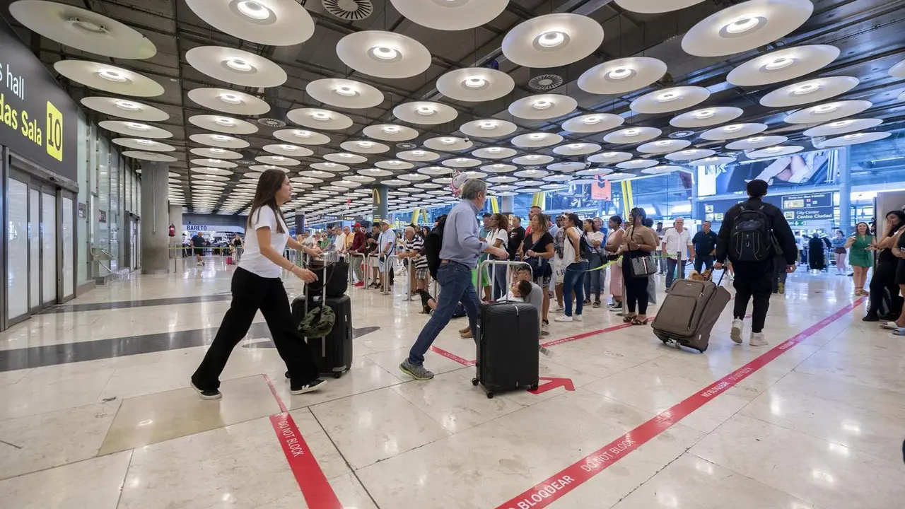 Varias personas con maletas en la terminal T4 del aeropuerto Adolfo Su&aacute;rez Madrid-Barajas.