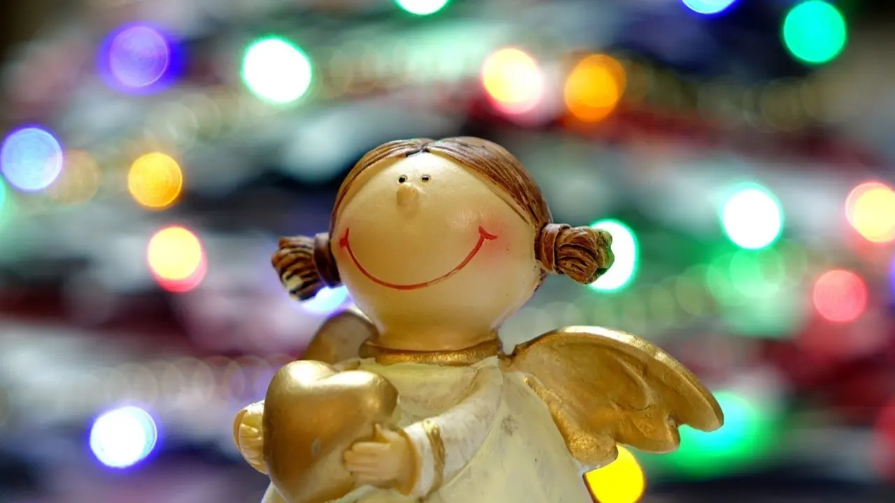 &Aacute;ngel con luces de Navidad de fondo.