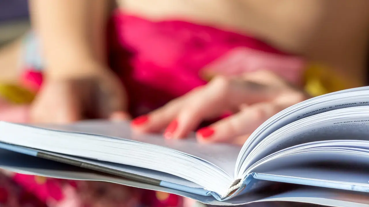 Imagen de archivo de una mujer con un libro entre las manos.