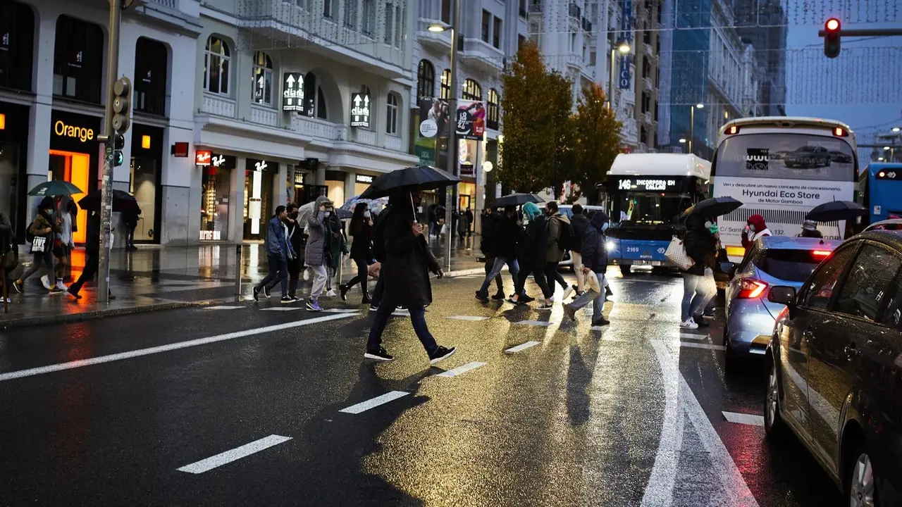 Varias personas caminando por Gran V&iacute;a bajo la lluvia,