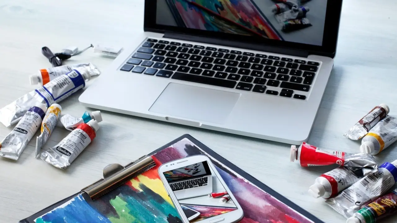 Espacio de trabajo con ordenador y pinturas.