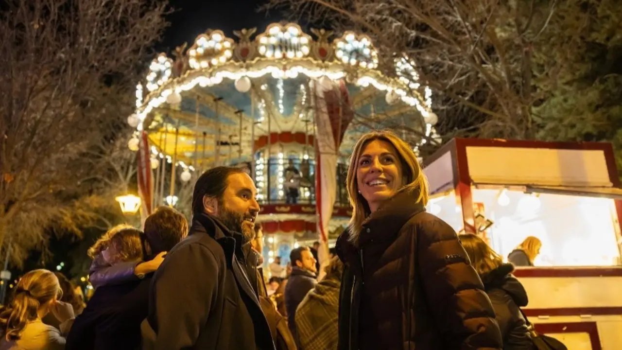 Una pareja disfrutando con un carrousel de fondo, imagen cedida por el Ayuntamiento de Pozuelo.