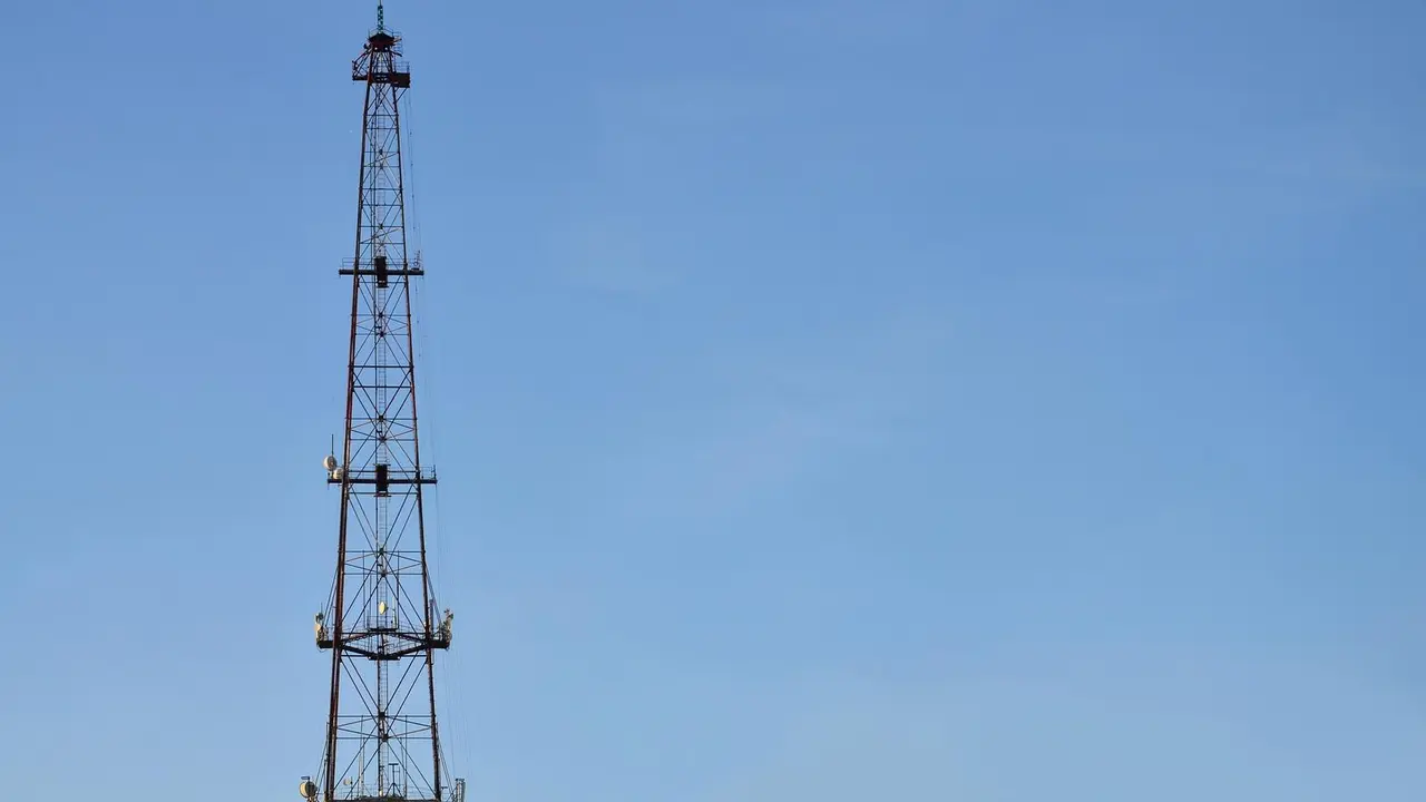 Torre de radiocomunicaciones delante de un cielo azul sin nubes. Imagen de archivo.