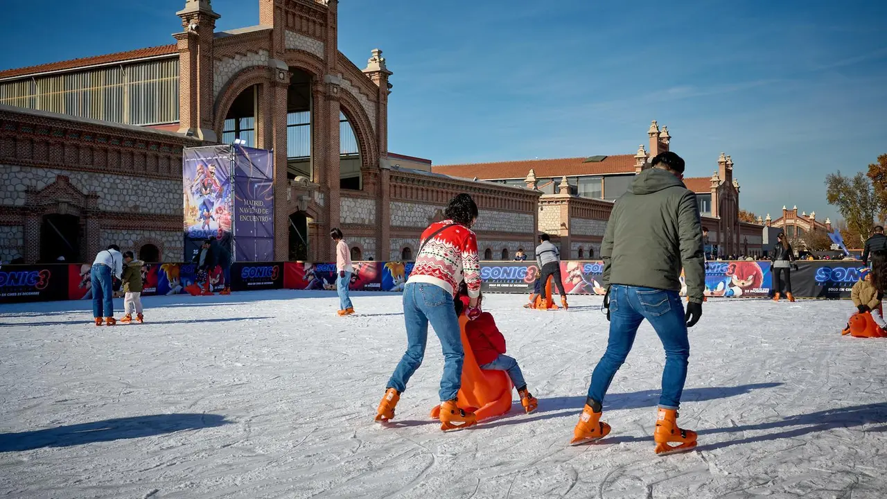 Pista de hielo de Matadero, en primer plano dos adultos y un ni&ntilde;o patinando. Fernando Tribi&ntilde;o &copy; Madrid Destino