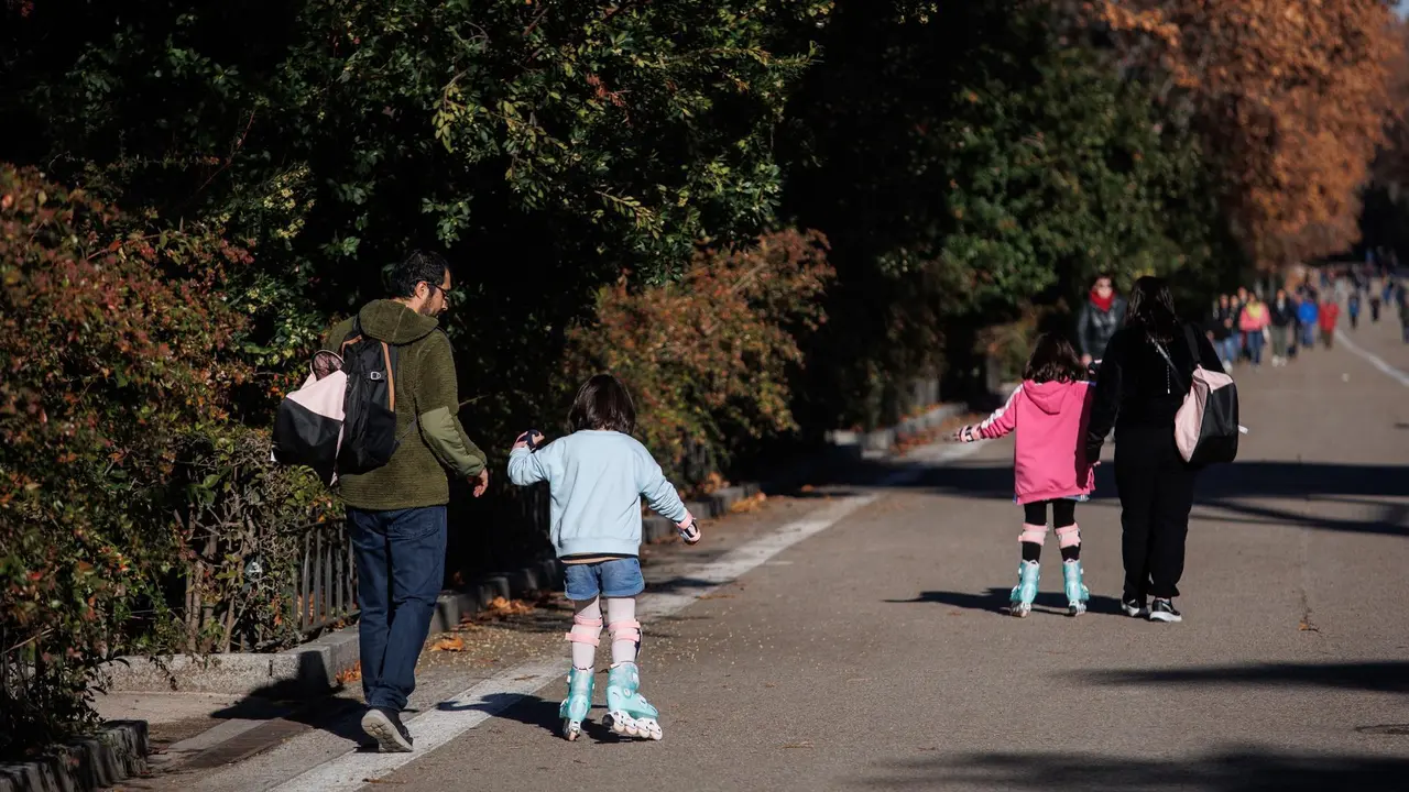 Dos ni&ntilde;as con sus padres jugando con los patines.