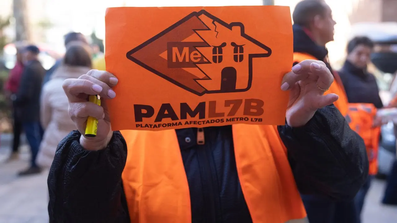 Una mujer porta una pancarta de la Plataforma de Afectados Metro L7B.