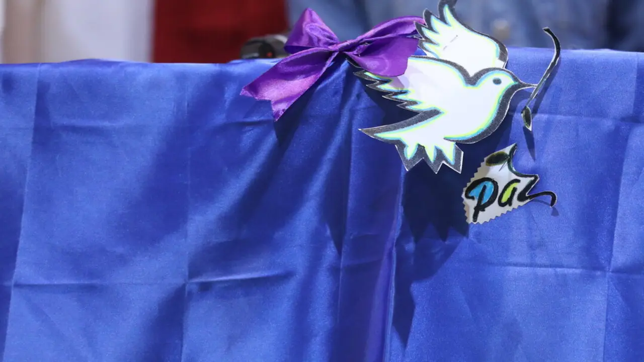 Archivo - Lazo morado colocado en una bandera de Ucrania en un acto para abordar el papel de las mujeres ucranianas en la guerra.