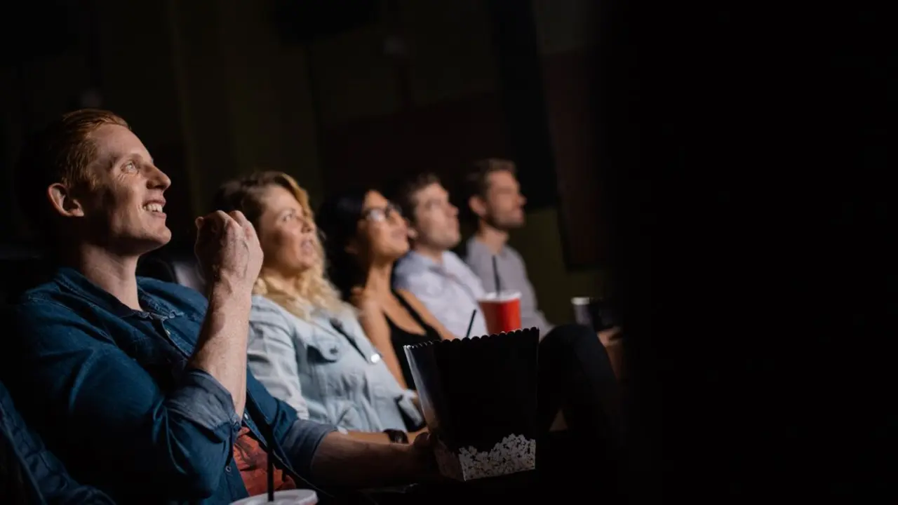 Grupo de amigos viendo una pel&iacute;cula en el cine. Imagen de archivo.
