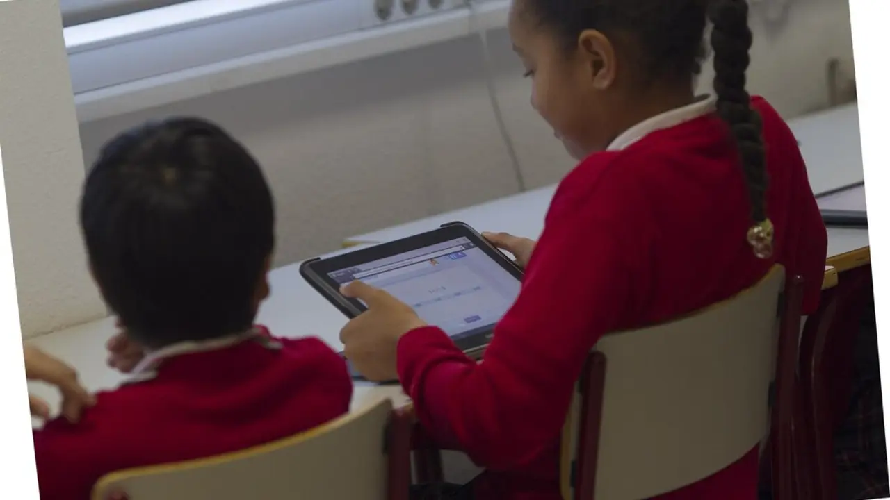 Ni&ntilde;os utilizan una tableta en un aula de Madrid.