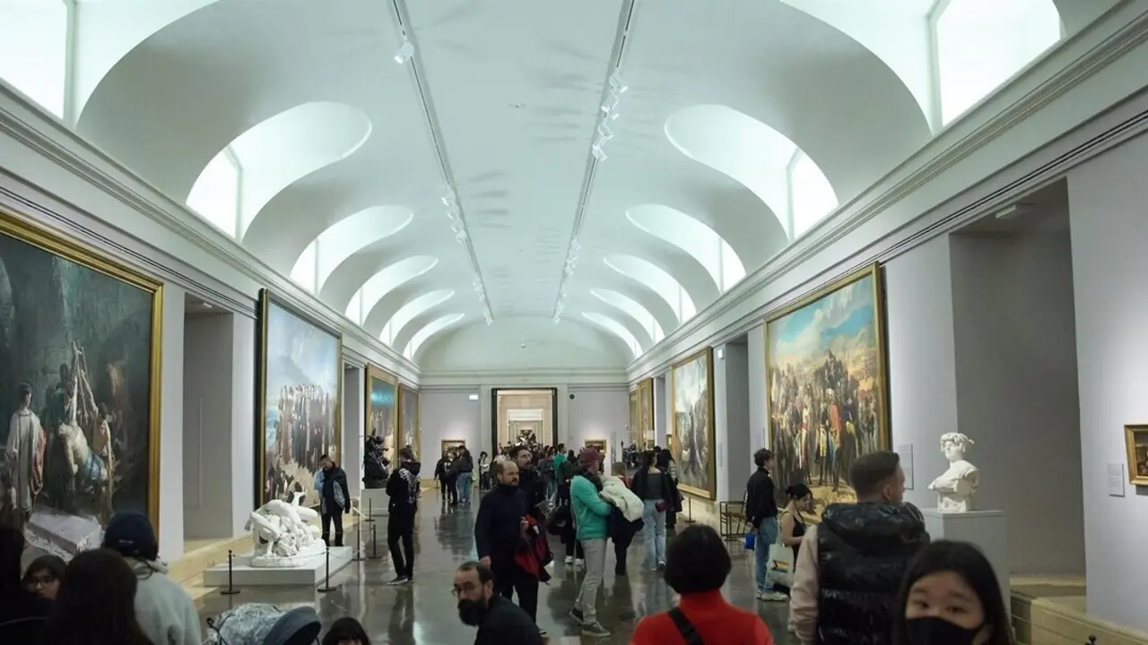 Varias personas durante una visita al Museo del Prado de noche.