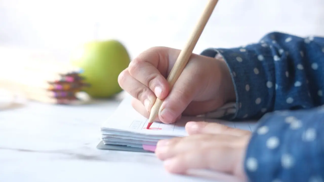 Un ni&ntilde;o o ni&ntilde;a escribiendo. Imagen de archivo.