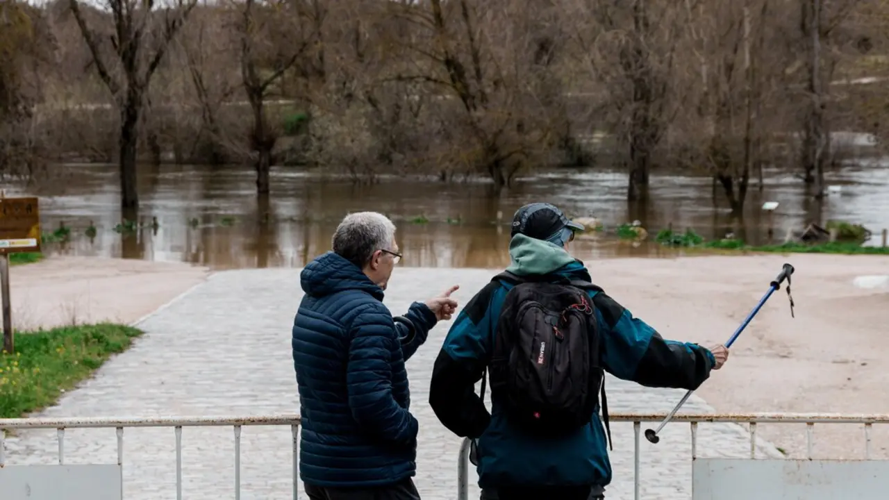 Dos observan el parking de Somontes inundado.
