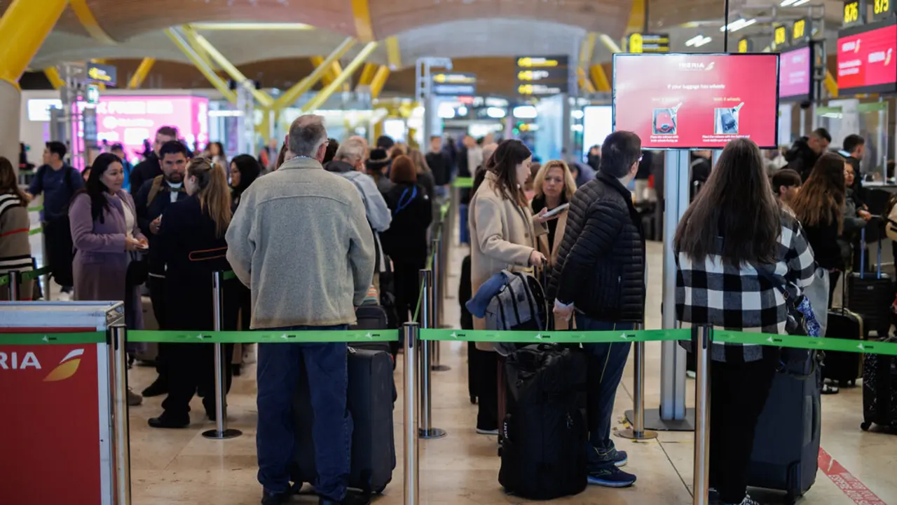 Varias personas con maletas hacen cola en la terminal T4 del aeropuerto de Adolfo Su&aacute;rez-Madrid Barajas.