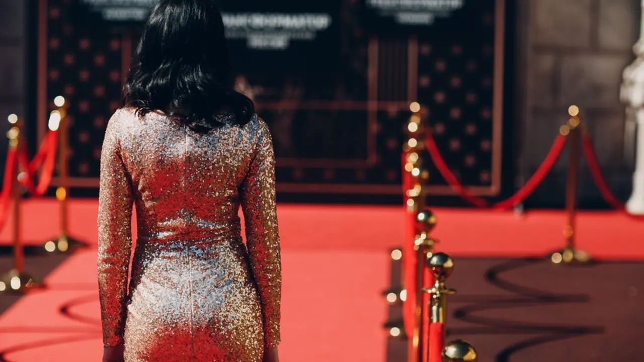 Mujer con vestido elegante en una alfombra roja. Imagen de archivo.