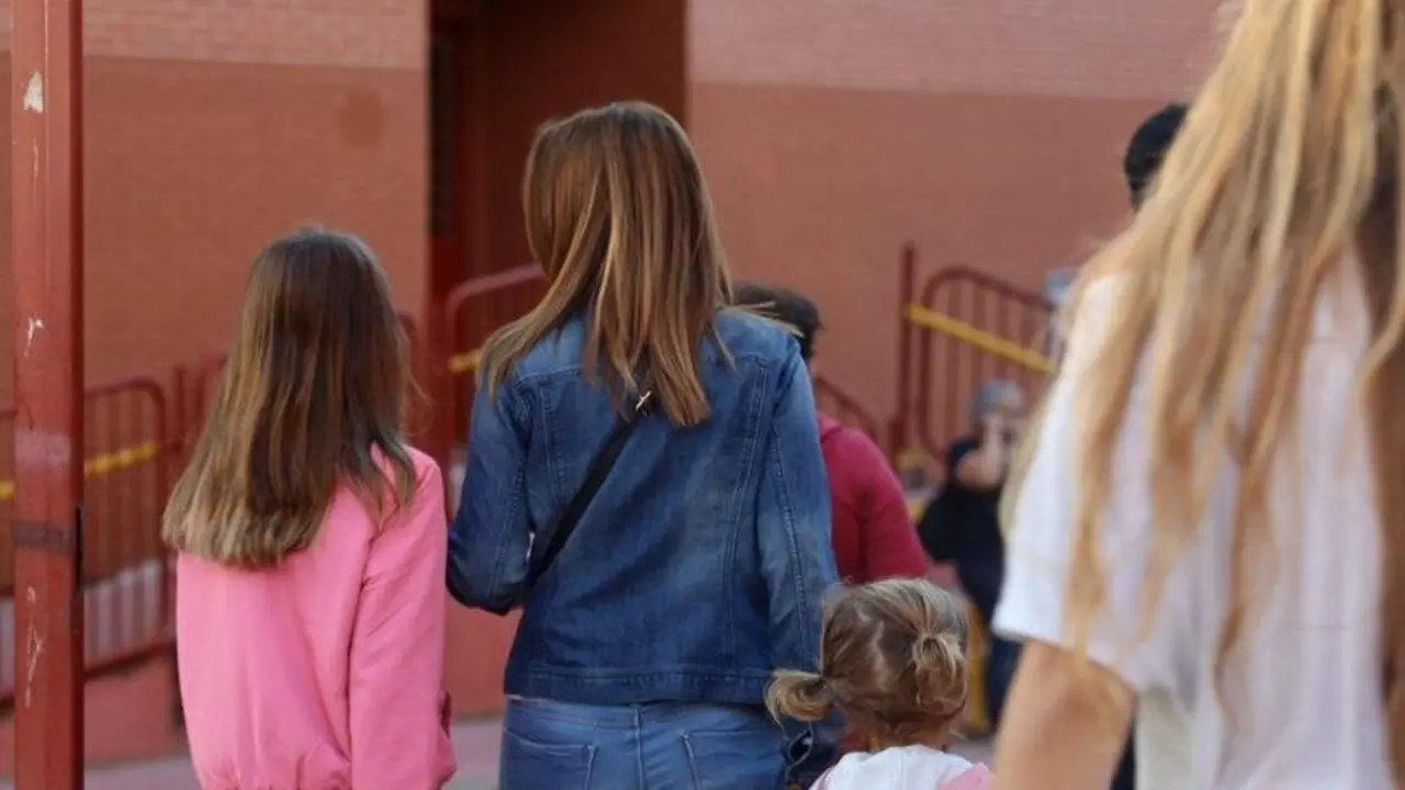 Una madre con sus hijas en el colegio.