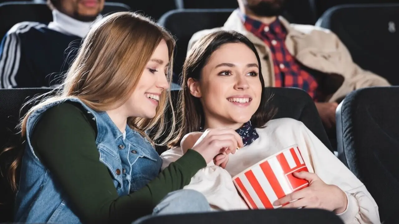 Dos amigas viendo una pel&iacute;cula en el cine. Imagen de archivo.