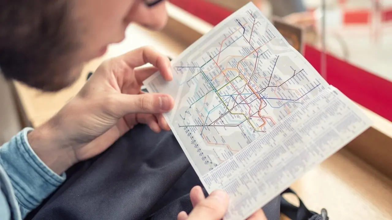 Hombre observando el mapa de transporte. Imagen de archivo.