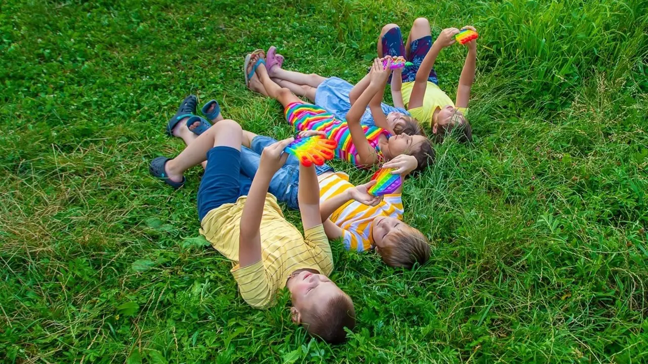 Ni&ntilde;os jugando en el pasto. Imagen de archivo.