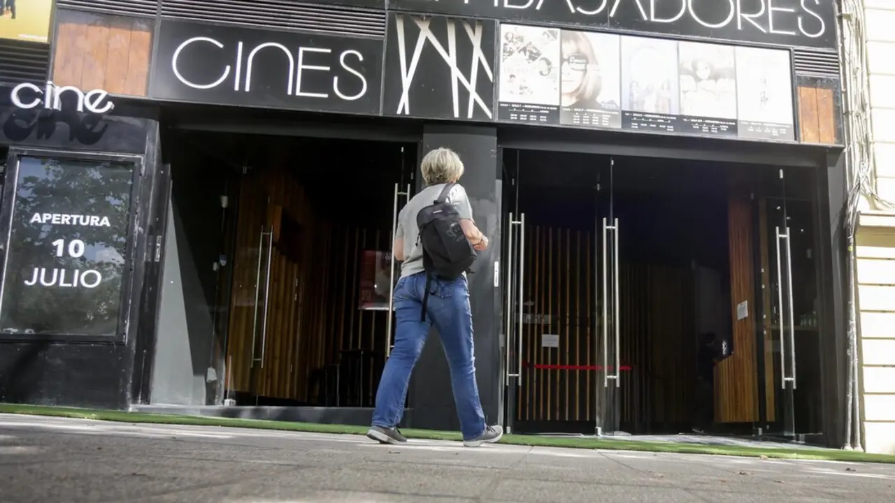 Una mujer pasa por la puerta de los Cines Embajadores el d&iacute;a en el que abre sus puertas tras el par&oacute;n por el coronavirus, en Madrid (Espa&ntilde;a), a 10 de julio de 2020. Durante su reapertura se proyecta la pel&iacute;cula 'Cinema Paradiso'. Imagen de EP.