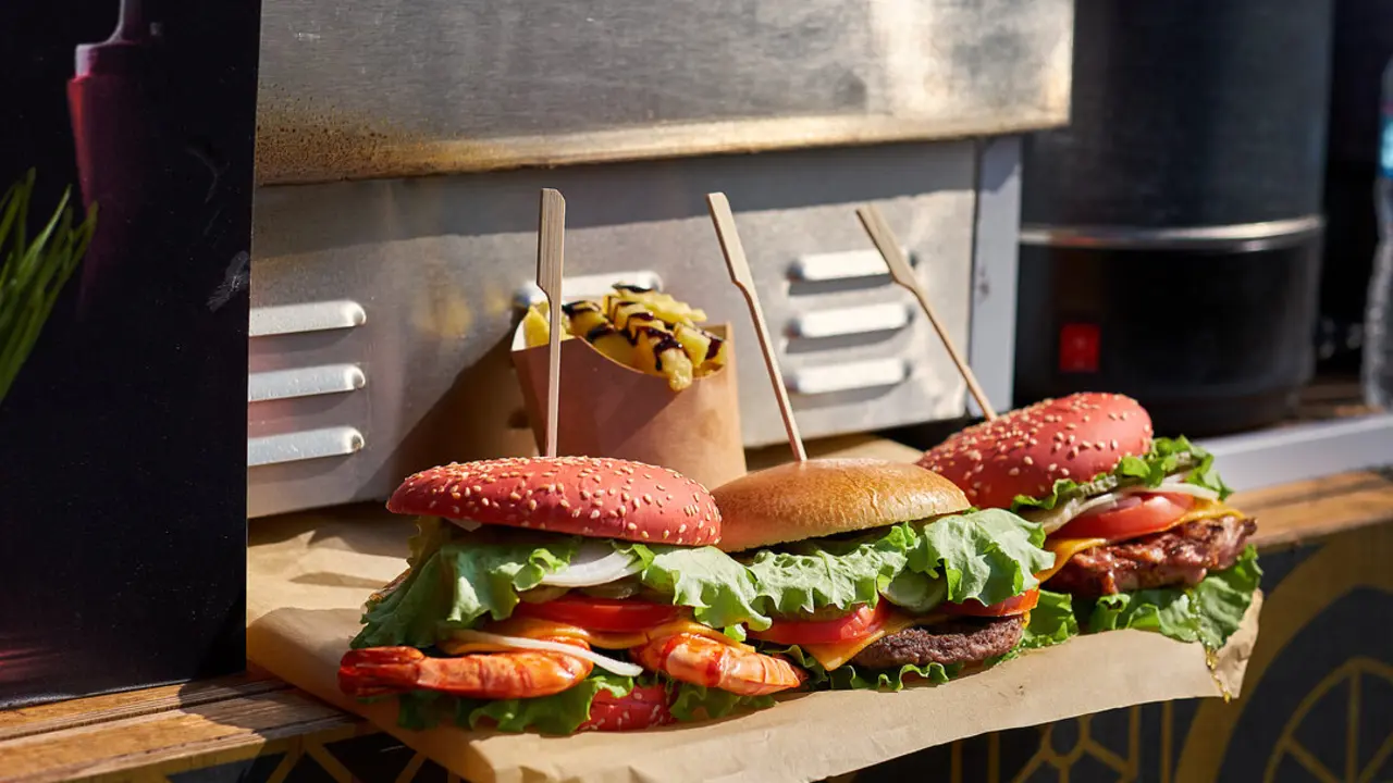Tres hamburguesas en un food truck. Imagen de archivo.